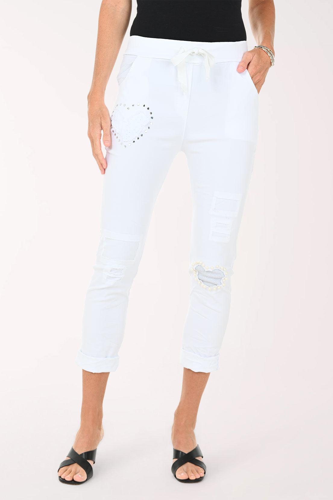 Person wearing white capri pants on a white background