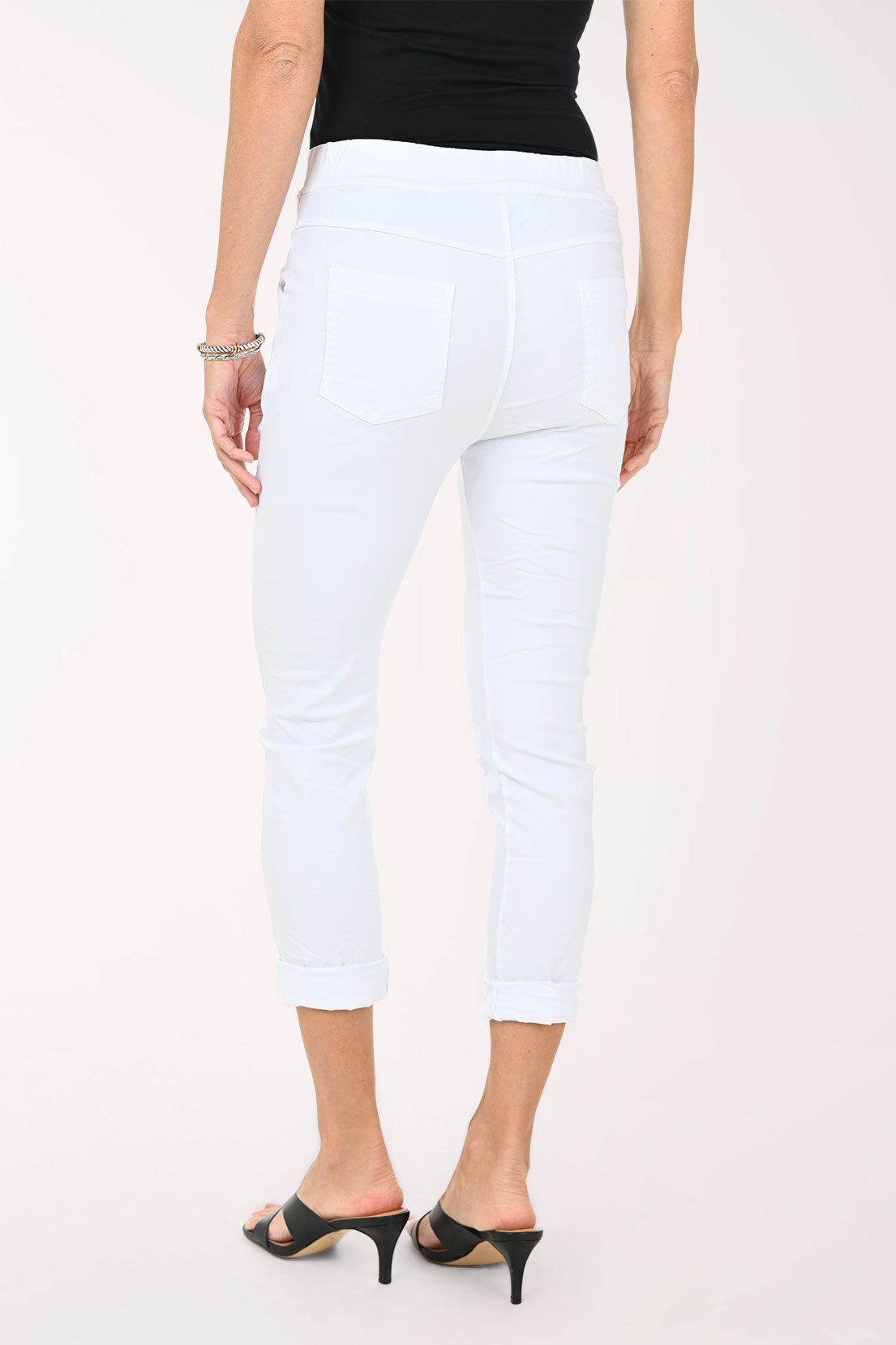 Person wearing white pants and a black top on a white background