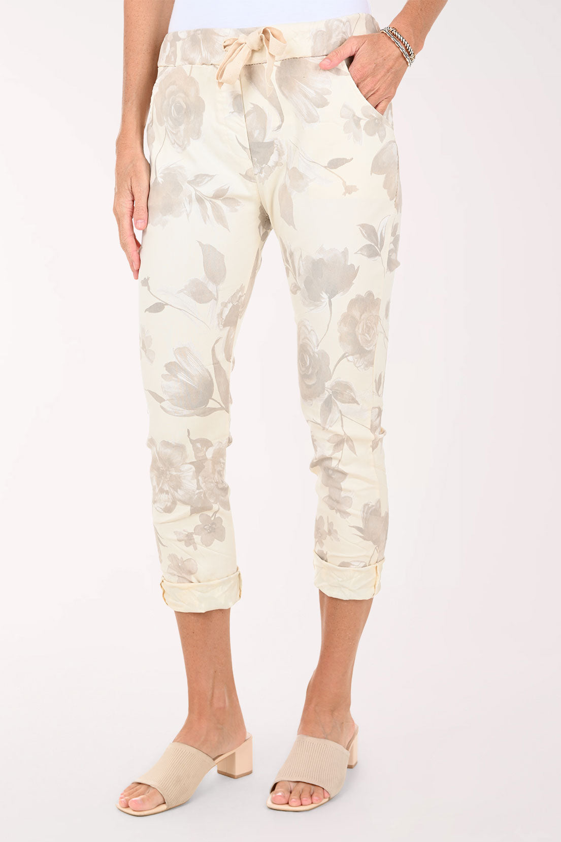 White pants with a subtle pattern worn by a person on a white background