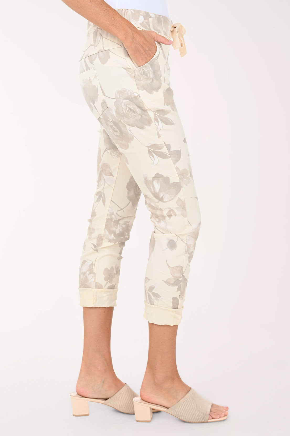 White pants with a subtle pattern worn by a person on a white background