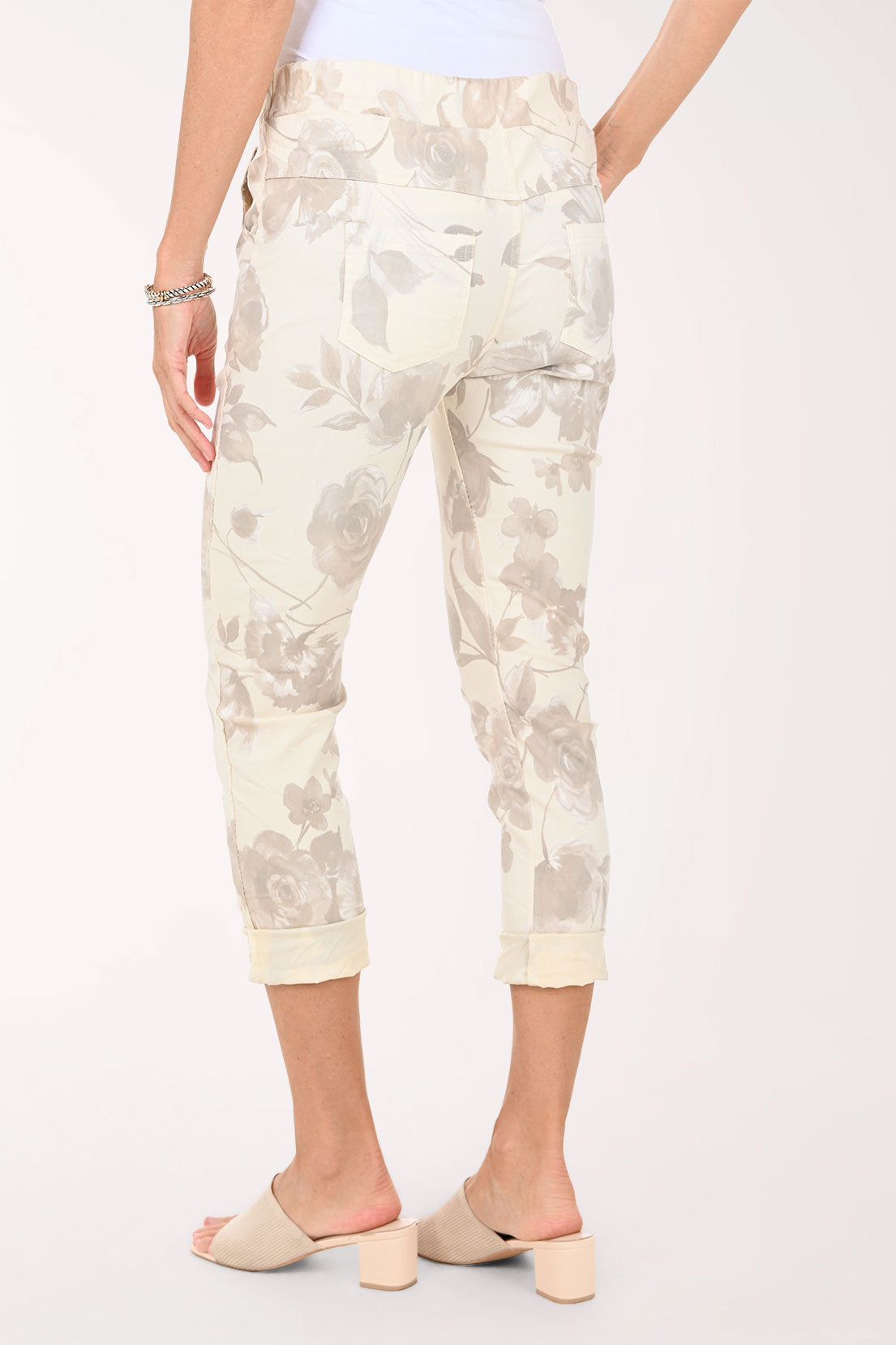 White pants with a subtle pattern worn by a person on a white background