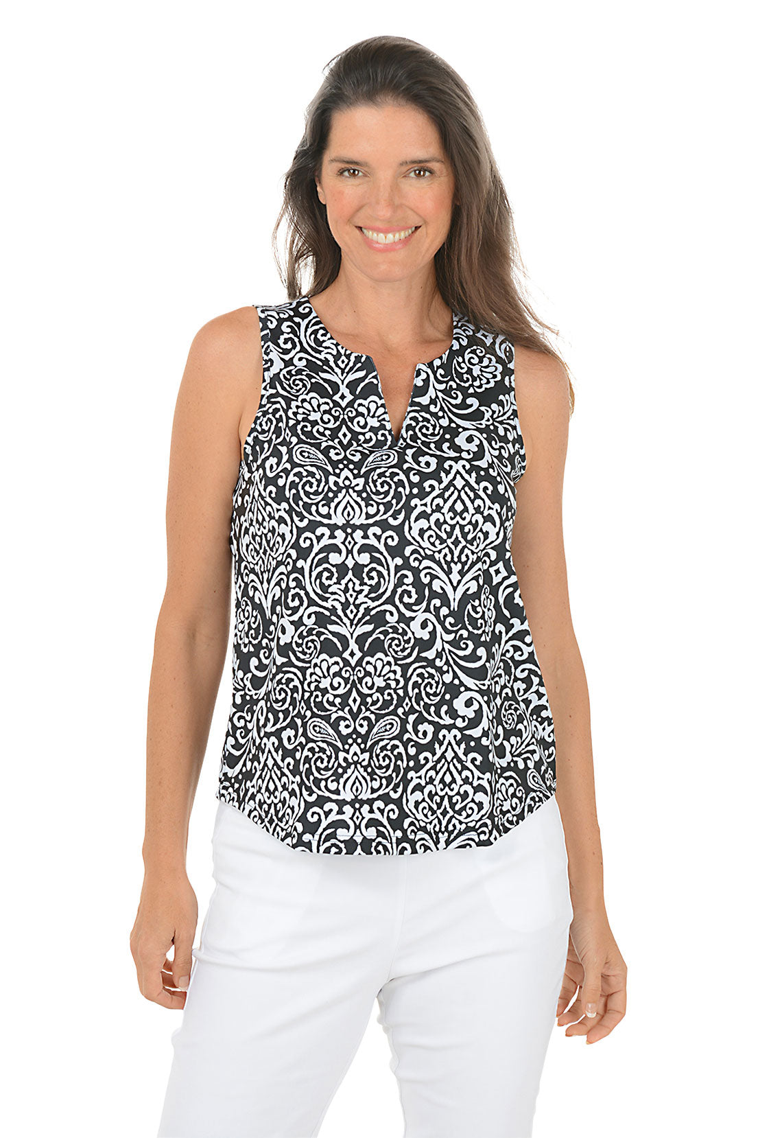 Woman wearing a black and white patterned sleeveless top with white pants on a white background