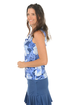 Woman wearing a blue floral sleeveless top and skirt on a white background. Side shot.