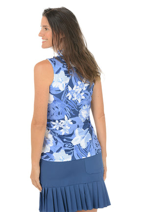 Woman wearing a blue floral sleeveless top and skirt on a white background. Back shot.