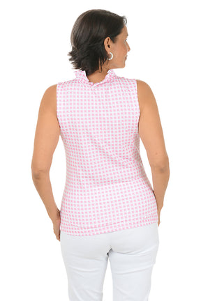 Woman wearing a pink checkered sleeveless top and white pants on a white background