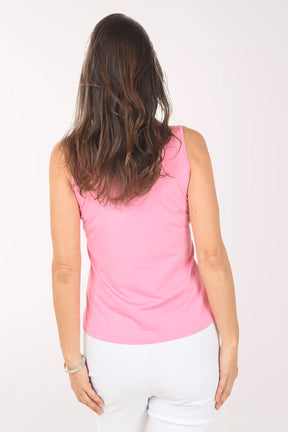 Woman wearing a pink sleeveless zip-up top on a white background