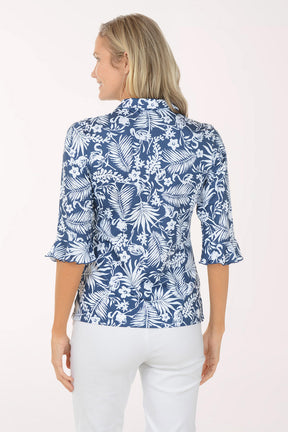 Woman wearing a blue floral blouse with white pants on a white background