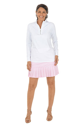 Woman wearing a white long-sleeve top and pink checkered skirt on a white background