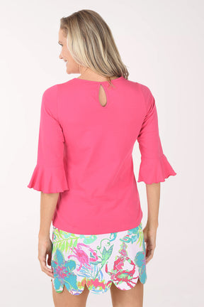 Woman wearing a pink top and colorful skirt on a white background