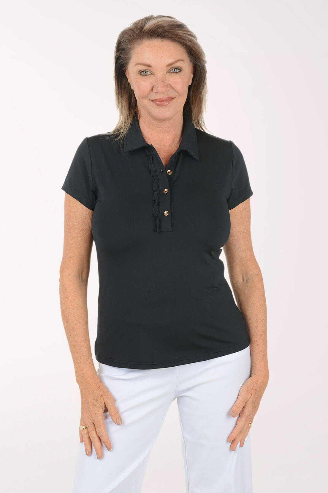 Woman wearing a black polo shirt with white pants on a white background