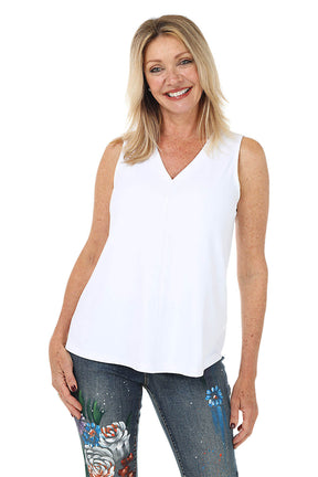 Woman wearing a white sleeveless top and colorful pants on a white background