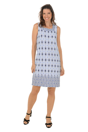 A woman wearing a sleeveless knee-length blue and white geometric pattern dress with a square neckline with rhinestone embellishment.