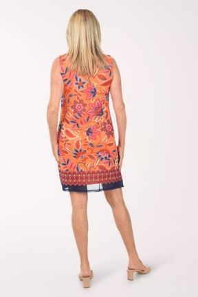Woman wearing an orange floral dress on a white background