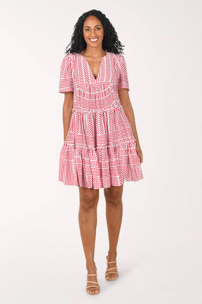 Woman wearing a red and white patterned dress on a white background