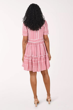 Woman wearing a red and white patterned dress on a white background