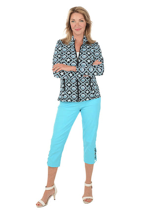 Woman wearing a patterned jacket and bright blue pants on a white background