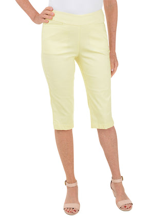 Person wearing light yellow capri pants on a white background.
