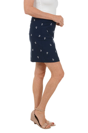 Navy blue skirt with white anchor pattern worn by a person on a white background. Side shot.