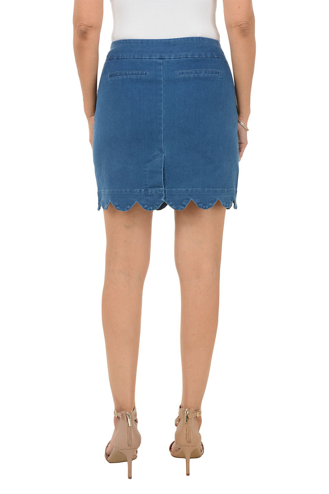 A woman wearing a pull-on denim scalloped hem skort. Back shot.