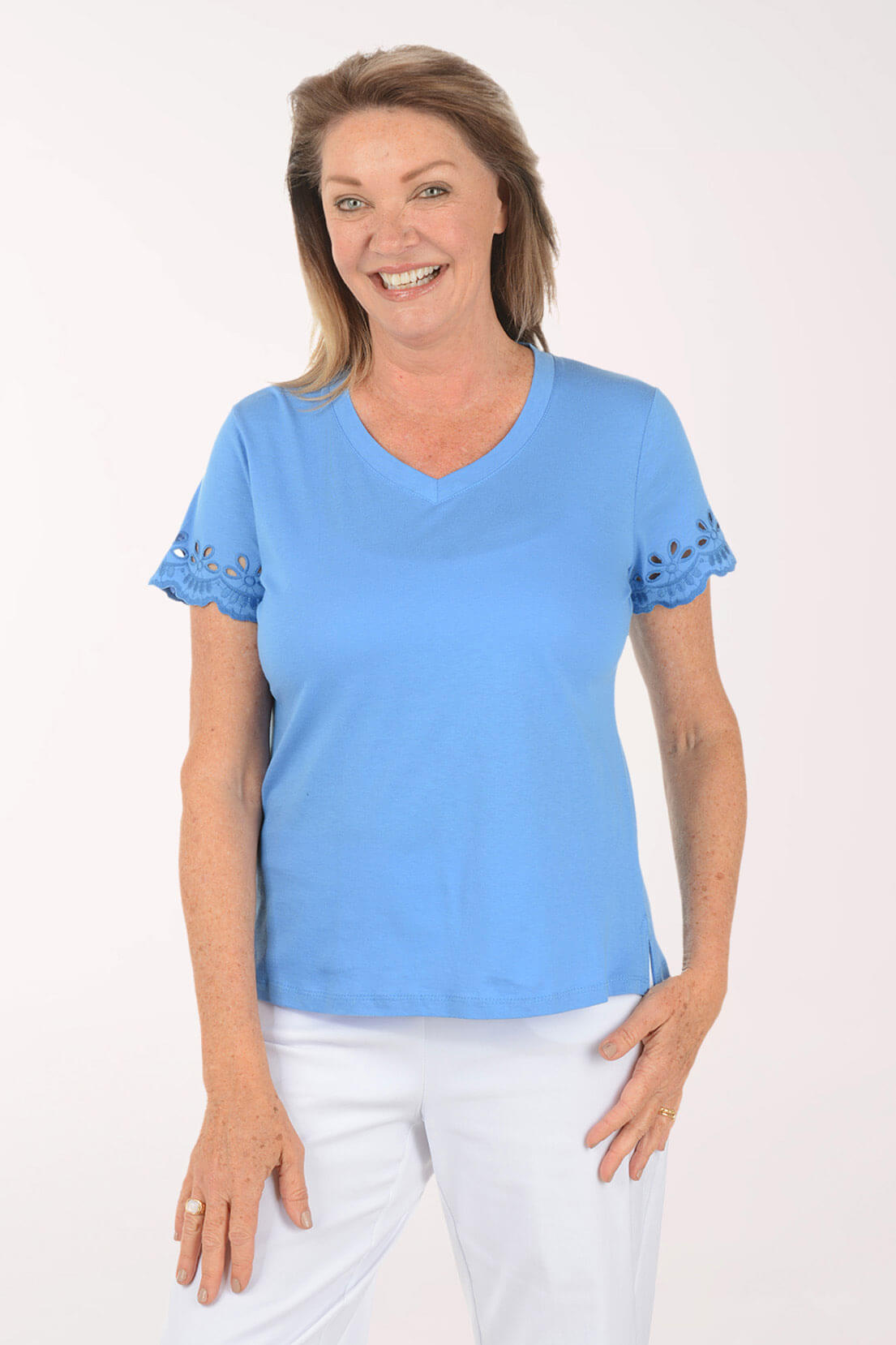 Woman wearing a blue shirt with white pants on a white background