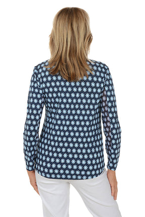 Woman wearing a navy blue floral patterned shirt on a white background