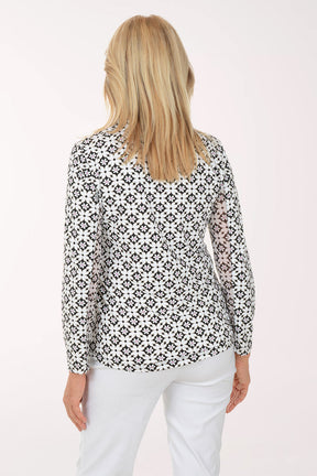 Woman wearing a black and white patterned shirt on a white background
