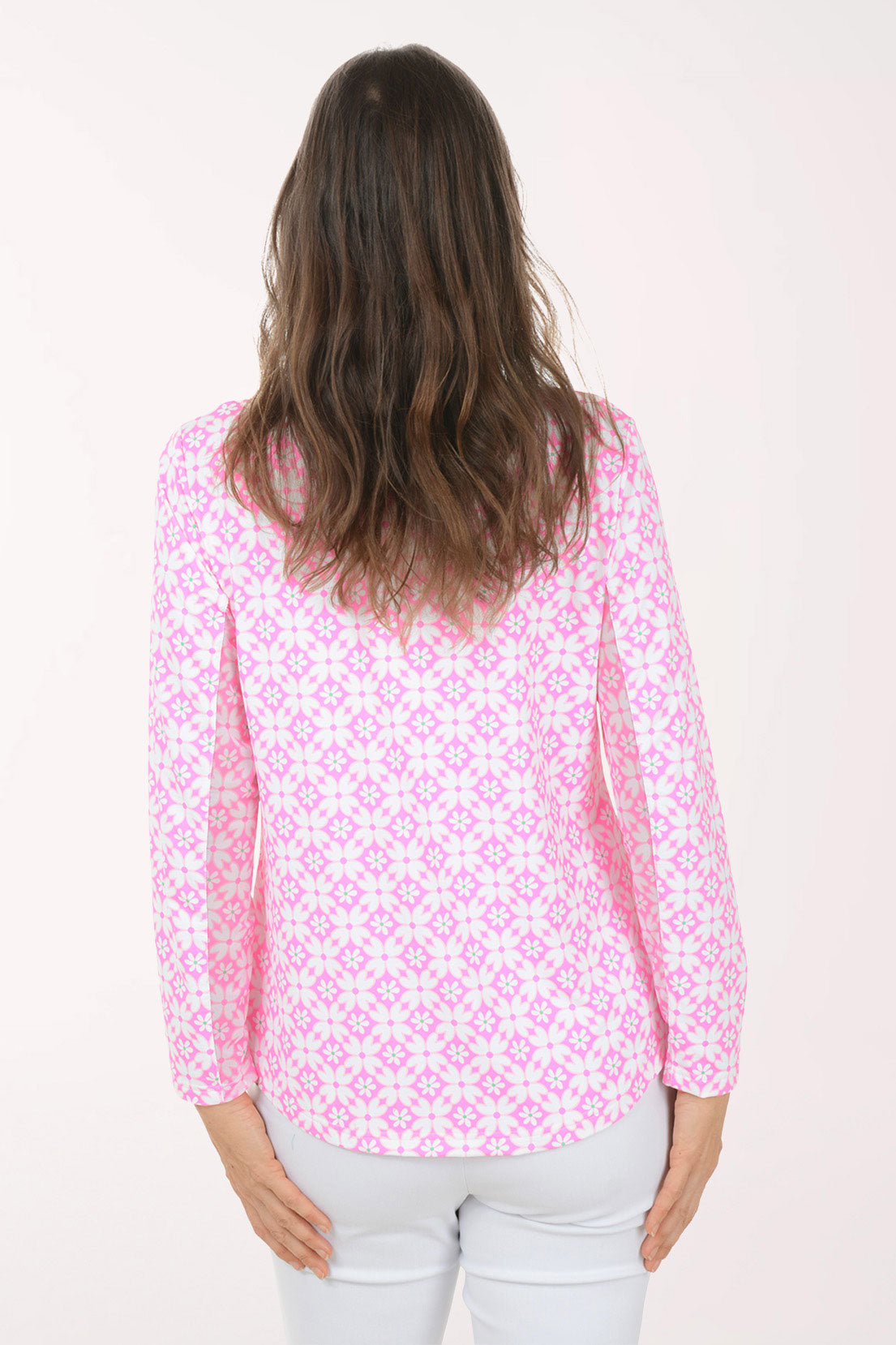 A woman wearing a long sleeve pink and white flower activewear top.