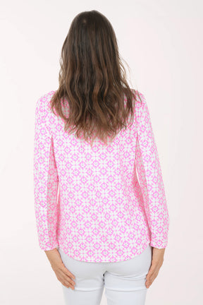 A woman wearing a long sleeve pink and white flower activewear top.