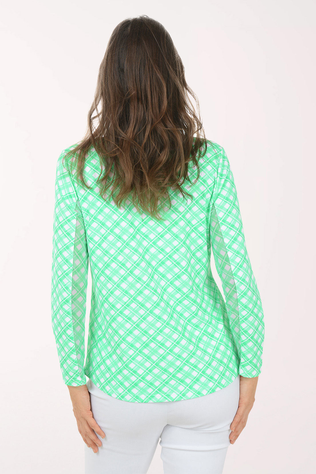 A woman wearing a long sleeve green plaid activewear top.