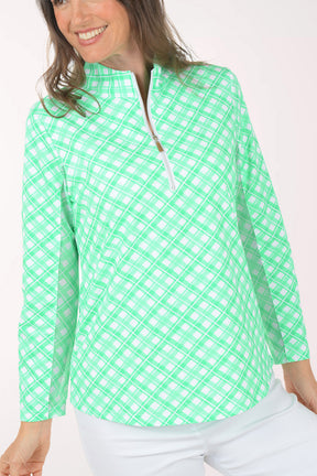 A woman wearing a long sleeve green plaid activewear top.