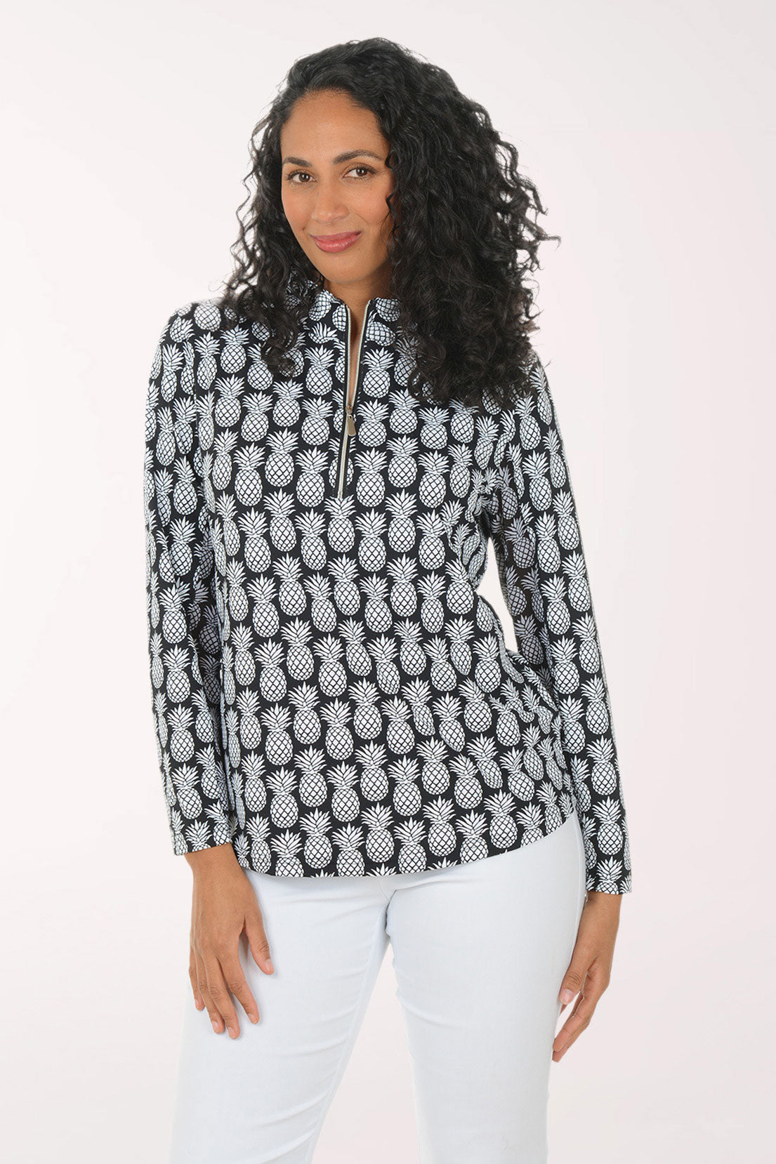 Woman wearing a black and white pineapple patterned top on a white background