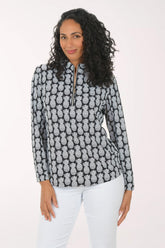 Woman wearing a black and white pineapple patterned top on a white background