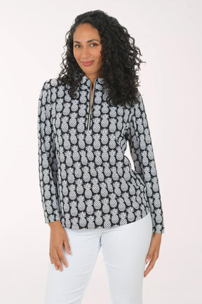 Woman wearing a black and white pineapple patterned top on a white background