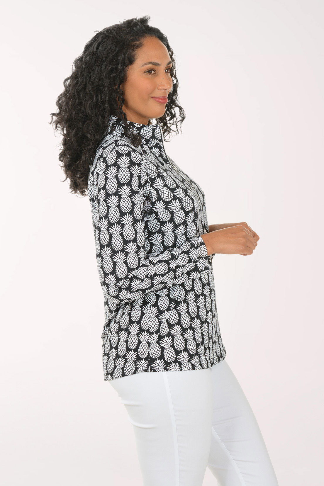 Woman wearing a black and white pineapple patterned top on a white background