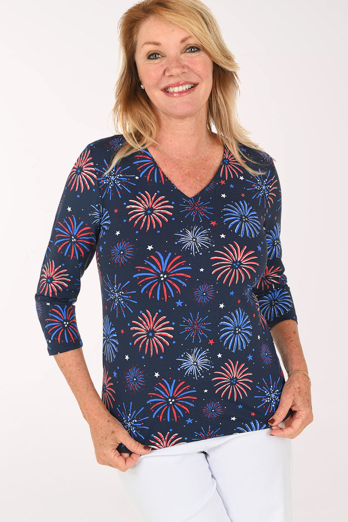 Woman wearing a navy 3/4 sleeve top with a firework print