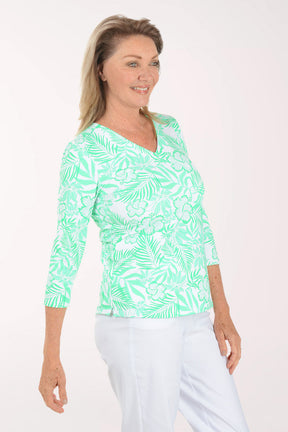 Woman wearing a green and white patterned top on a white background