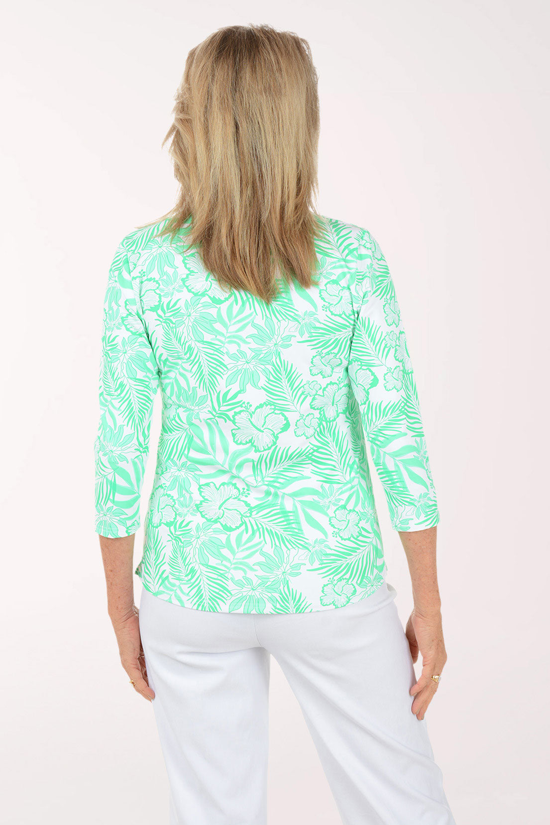 Woman wearing a green and white patterned top on a white background