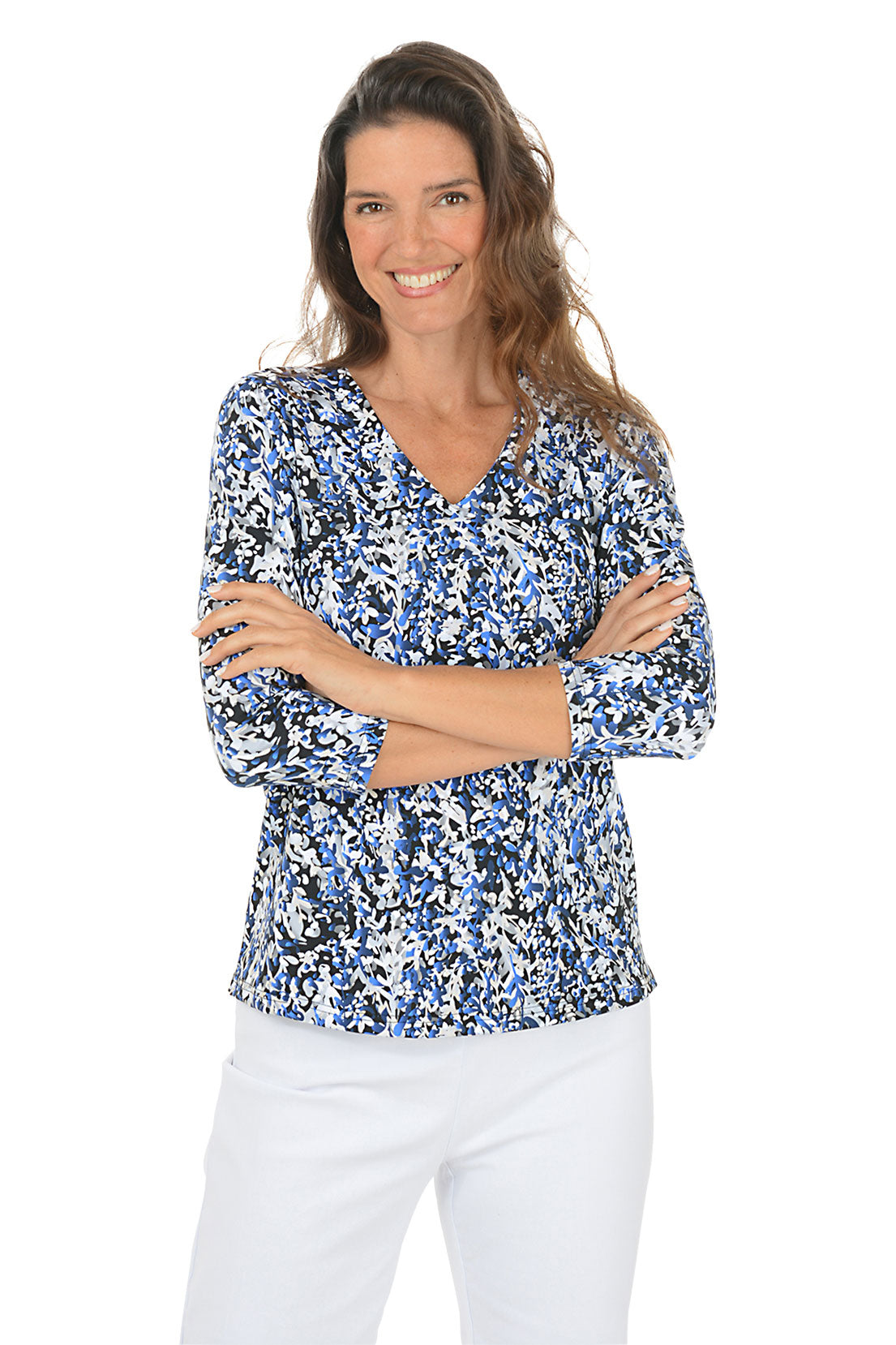 Woman wearing a 3/4 sleeve blue floral blouse and white pants on a white background.