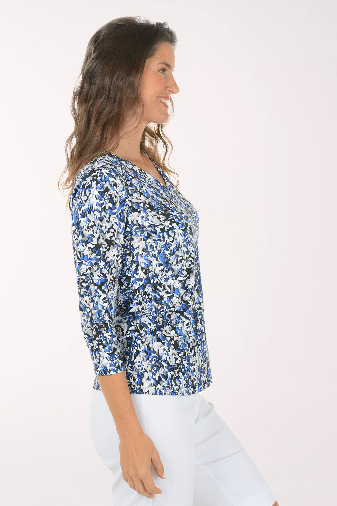 Side profile of the Growing Vines UPF50+ V-Neck Top showing the 3/4 sleeve and straight hem worn over white pants.