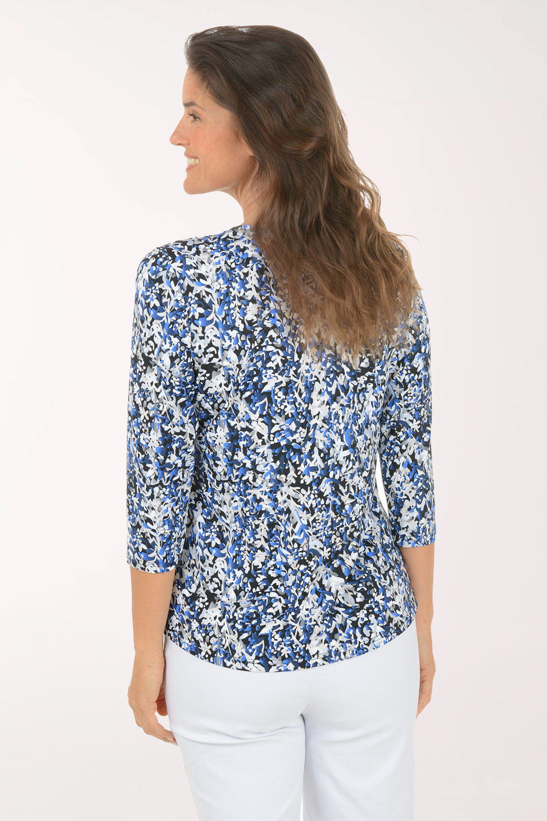 Back view of the Growing Vines UPF50+ V-Neck Top as the model looks over her shoulder, showing the blue and white vine print across the back.