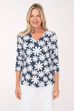 Woman wearing a navy blue floral patterned top on a white background