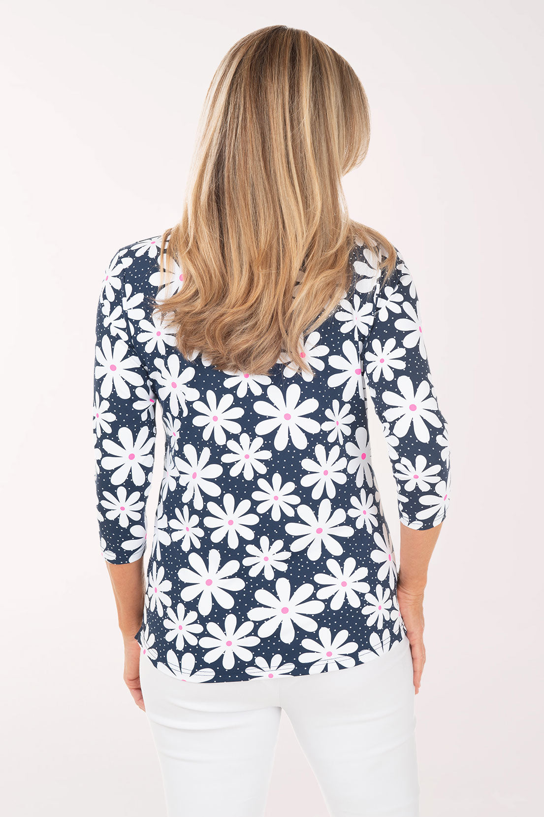 Woman wearing a navy blue floral patterned top on a white background