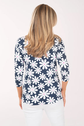 Woman wearing a navy blue floral patterned top on a white background