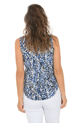 Woman wearing a sleeveless blue and white patterned top on a white background. Back shot.