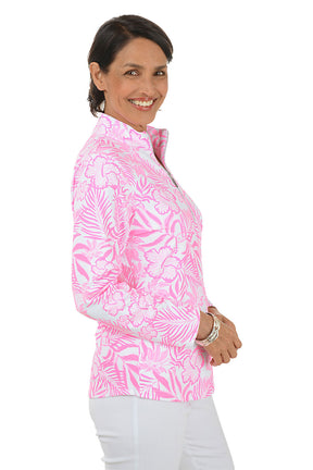 Woman wearing a pink floral patterned shirt with a white background. Side shot.