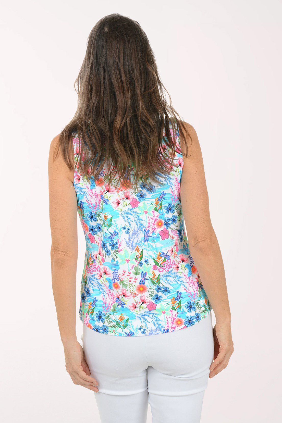 A woman wearing a multicolored sleeveless floral top.