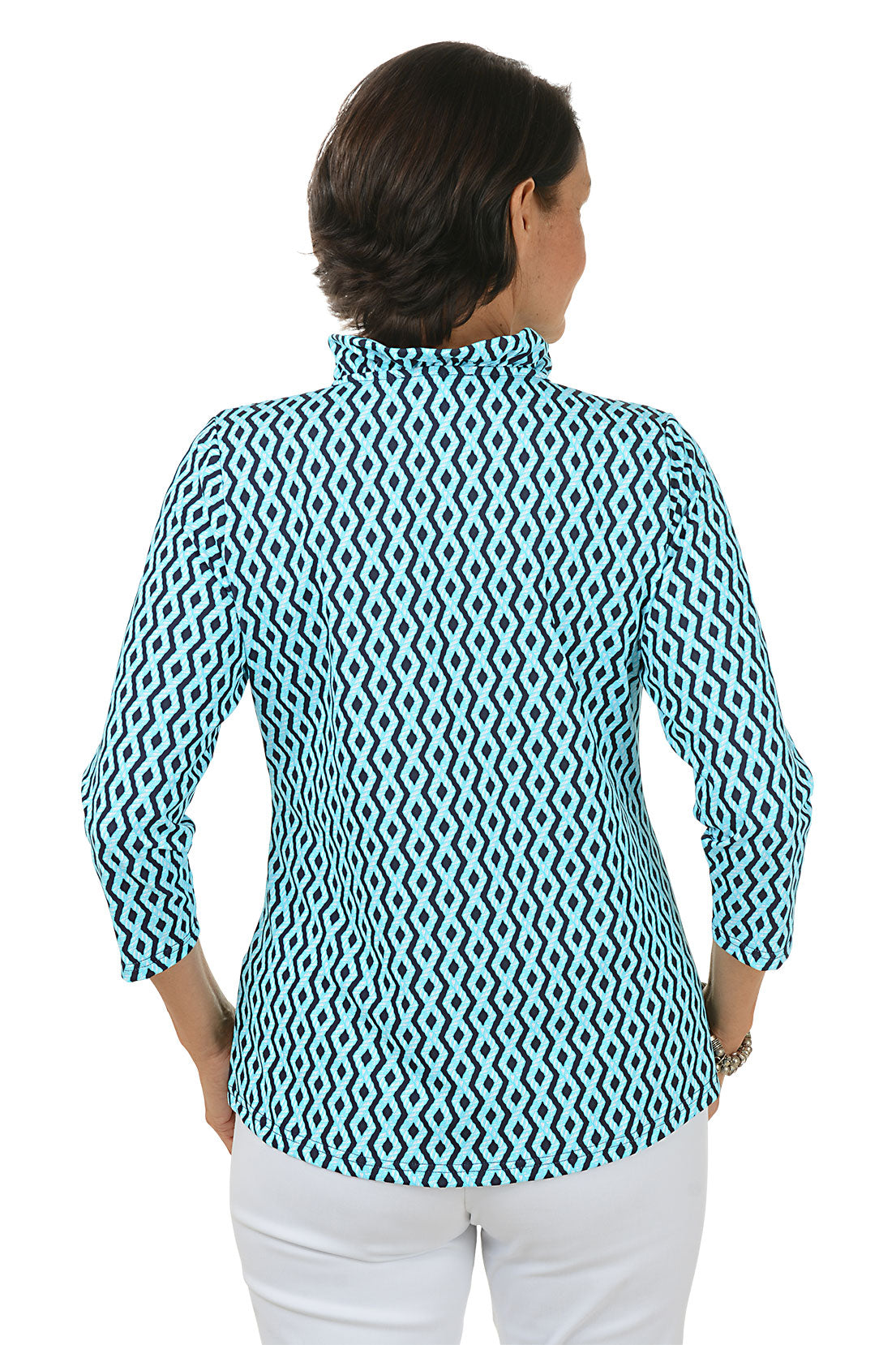 Woman wearing a blue and white patterned shirt with white pants on a white background. Back shot.
