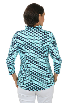 Woman wearing a blue and white patterned shirt with white pants on a white background. Back shot.