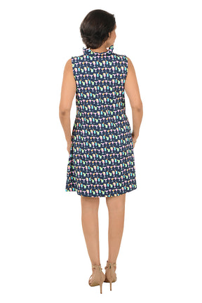 Woman wearing a patterned sleeveless dress on a white background. Back shot.