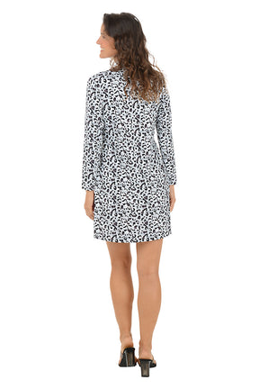A woman wearing a long sleeve dress with a white leopard pattern and half-zip placket  detail along the neckline. Back shot.